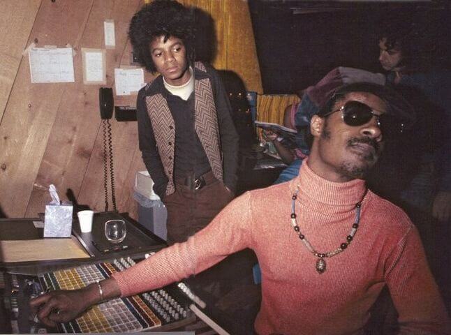 A very young Michael Jackson notes with admiration for a well at a young Stevie Wonder in the Motown studio